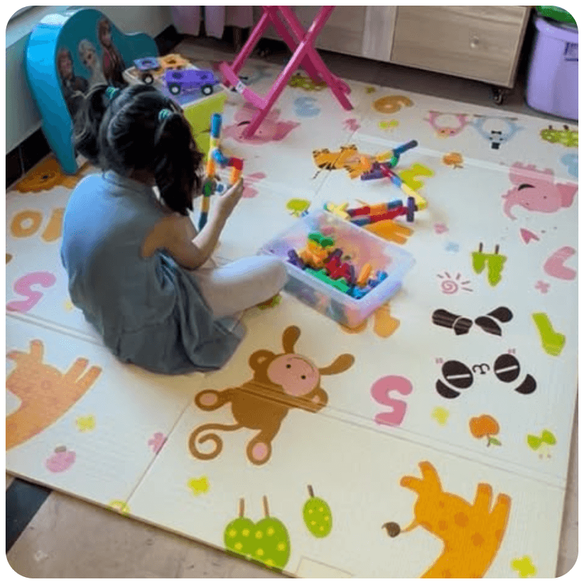 Child playing on a colorful animal play mat